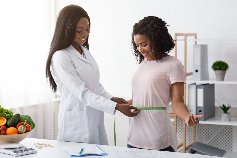 Young,Black,Woman,Taking,Body,Measurements,At,Dietologist,,Clinic,Interior